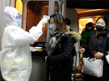 Health Officials in hazmat suits check body temperatures of passengers arriving from the city of Wuhan Wednesday, Jan. 22, 2020, at the airport in Beijing, China. Nearly two decades after the disastrously-handled SARS epidemic, China's more-open response to a new virus signals its growing confidence and a greater awareness of …