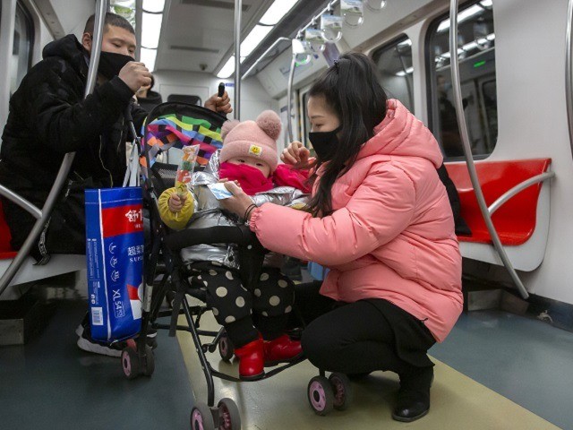 People wearing face masks attend to a child in a stroller as they ride a subway train in Beijing, Sunday, Jan. 26, 2020. The new virus accelerated its spread in China, and the U.S. Consulate in the epicenter of the outbreak, the central city of Wuhan, announced Sunday it will …