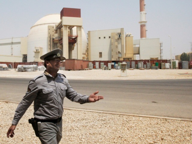In this Aug. 21, 2010 file photo, an Iranian security officer directs media at the Bushehr nuclear power plant, with the reactor building seen in the background, just outside the southern city of Bushehr, Iran. State TV says the Guardian Council, Iran's constitutional watchdog, ratified a bill Wednesday, June 24, …