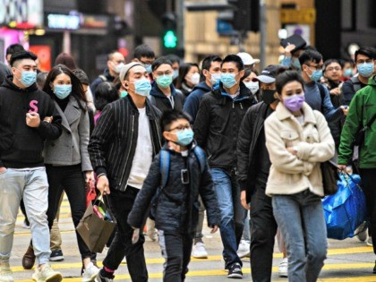 Pedestrians wearing face masks cross a road during a Lunar New Year of the Rat public holiday in Hong Kong on January 27, 2020, as a preventative measure following a coronavirus outbreak which began in the Chinese city of Wuhan. (Photo by Anthony WALLACE / AFP) (Photo by ANTHONY WALLACE/AFP …