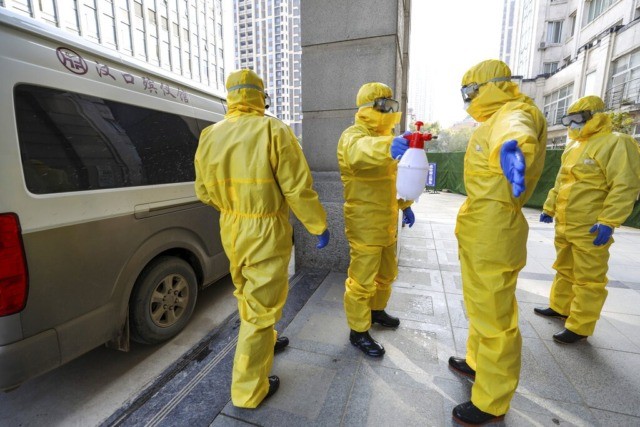 Funeral workers disinfect themselves after handling a virus victim in Wuhan in central Chi