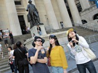 FILE - In this June 15, 2012, file photo, a group of tourists from China take in the sights of the New York Stock Exchange and Federal Hall National Memorial, in New York. With tens of millions of Chinese ordered to stay put and many others opting to avoid travel …