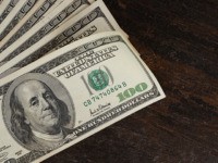 American dollars banknotes on old wooden table background. Dollars money on table.