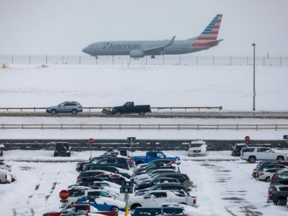 DENVER, CO - NOVEMBER 26: A jet passes snow-covered cars parked at Denver International Airport on November 26, 2019 in Denver, Colorado. Flights were delayed and rescheduled due to a winter storm that dropped nearly a foot of snow in the city. (Photo by Joe Mahoney/Getty Images)