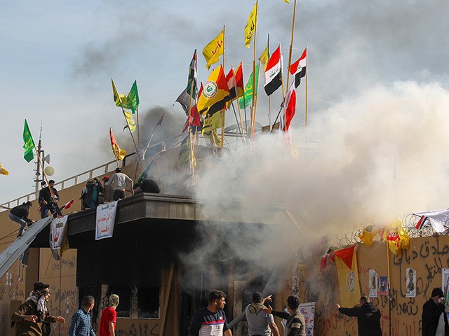 US forces (unseen) fire teargas canisters at supporters and members of the Hashed al-Shaab
