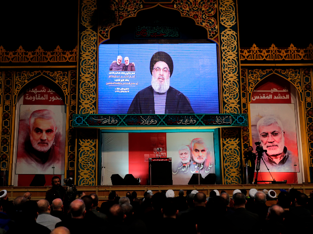 Supporters of the the Shiite Hezbollah movement watch as the movement's leader Hasan Nasra