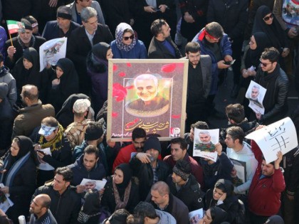 Iranian mourners lift a picture of slain military commander Qasem Soleimani during a funeral procession in the capital Tehran on January 6, 2020, for him as well as Iraqi paramilitary chief Abu Mahdi al-Muhandis and other victims of a US attack. - Downtown Tehran was brought to a standstill as …