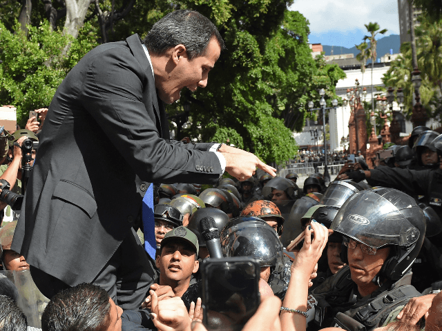 Venezuelan opposition leader and self-proclaimed acting president Juan Guaido confronts Bolivarian National Guard members upon arrival at the National Assembly, in Caracas, on January 7, 2020. - Opposition leader Juan Guaido and a rival lawmaker, Luis Parra -who both had claimed to be Venezuela's parliament speaker, following two separate votes …