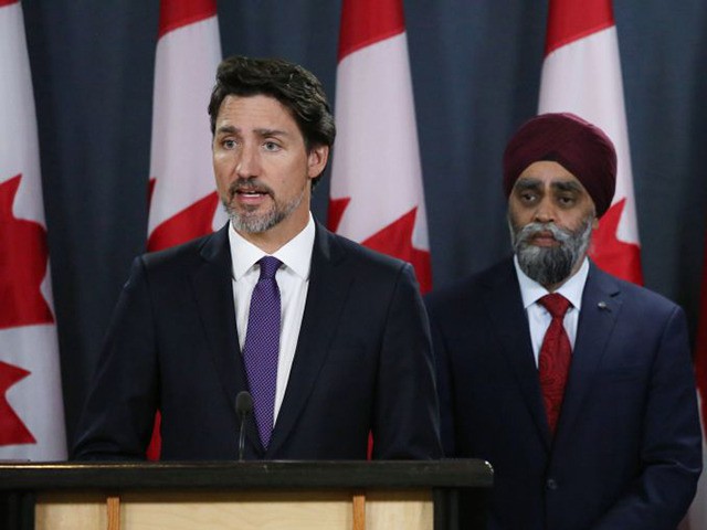Minister of National Denfence Harjit Sajjan (C) and Chief of Defence Staff General Jonatha