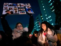 TOPSHOT - A woman holds a sign for one of the victims of Ukrainian Airlines flight 752 which crashed in Iran, during a vigil at Mel Lastman Square in Toronto, Ontario on January 9, 2020. - A Ukrainian airliner crashed shortly after take-off from Tehran on January 8 killing all …