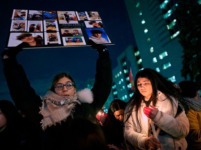 TOPSHOT - A woman holds a sign for one of the victims of Ukrainian Airlines flight 752 whi