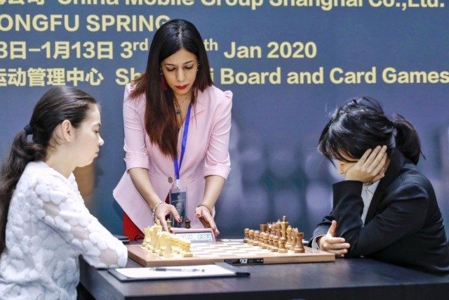 Shohreh Bayat (C), chief arbiter for the match between Aleksandra Goryachkina (front L) of Russia and Ju Wenjun (front R) of China, prepares for the match during the 2020 International Chess Federation (FIDE) Women's World Chess Championship in Shanghai on January 11, 2020. (Photo by STR / AFP) / China …