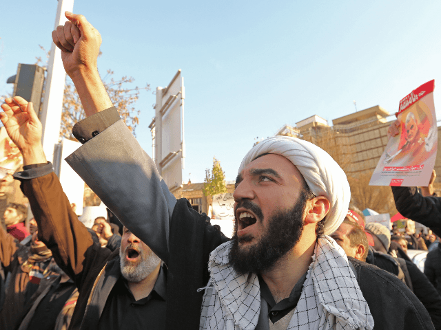 Iranian demonstrators hold placards bearing the image of slain military commander Qasem So