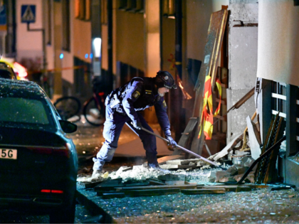 Police work at the site where an explosion damaged a residential building in central Stock