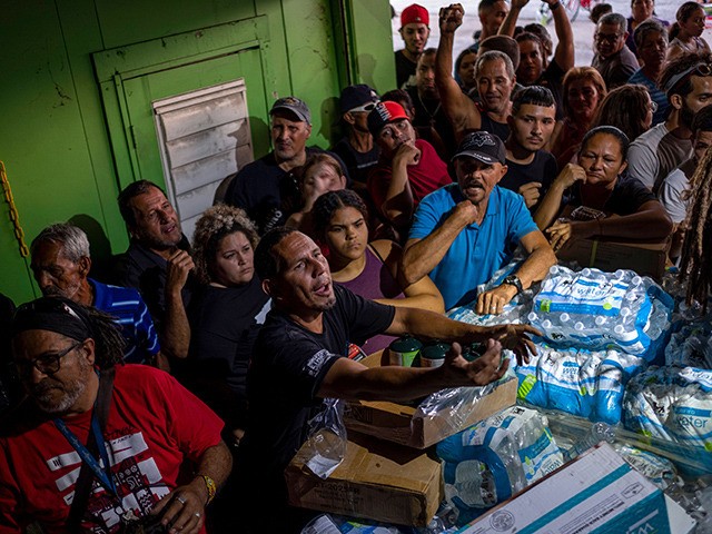 People break into a warehouse with supplies believed to have been from when Hurricane Maria struck the island in 2017 in Ponce, Puerto Rico on January 18, 2020, after a powerful earthquake hit the island. - President Donald Trump on January 16 freed up emergency aid for Puerto Rico's recovery …