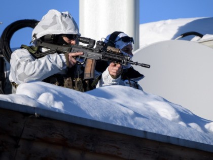 Policemen wearing camouflage clothing stands on the rooftop of a hotel near the Congress Centre during the World Economic Forum (WEF) annual meeting in Davos, on January 20, 2020. (Photo by Fabrice COFFRINI / AFP) (Photo by FABRICE COFFRINI/AFP via Getty Images)