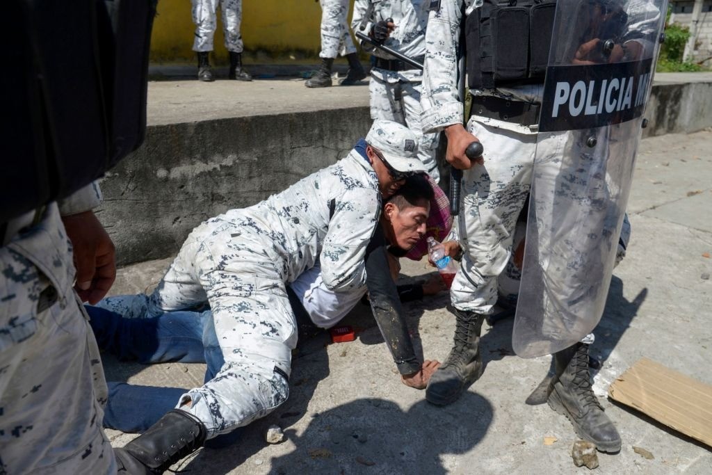A Central American migrant - part of a group of mostly Hondurans travelling on caravan to the US- is detained by a member of Mexico's National Guard after crossing the Suichate River. (Photo by ISAAC GUZMAN/AFP via Getty Images)