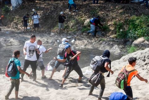 A Central American migrant - part of a caravan of mostly Hondurans travelling to the US- throws a stone to members of Mexico's National Guard after crossing the Suichate River, the natural border between Tecun Uman in Guatemala and Ciudad Hidalgo in Mexico, on January 20, 2020. - Hundreds of Central Americans from a new migrant caravan tried to enter Mexico by force Monday by crossing the river that divides the country from Guatemala, prompting the National Guard to fire tear gas, an AFP correspondent said. (Photo by JOHAN ORDONEZ/AFP via Getty Images)