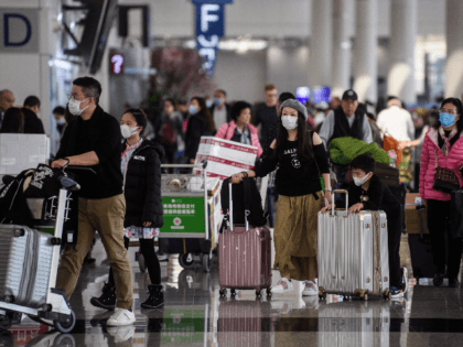 Passengers wear face masks at Hong Kong's international airport on January 22, 2020, after China recently confirmed human-to-human transmission in the outbreak of the new SARS-like virus. - A new virus that has killed nine people, infected hundreds and already reached the United States could mutate and spread, China warned …