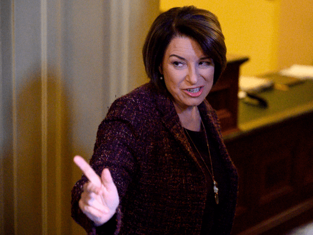US Senator and presidential candidate Amy Klobuchar (D-MN) (R) gestures during a recess in the Senate impeachment trial of US President Donald Trump at the US Capitol in Washington, DC, January 22, 2020. - In a somber and hushed Senate chamber, Democrats began presenting their opening arguments in the impeachment …