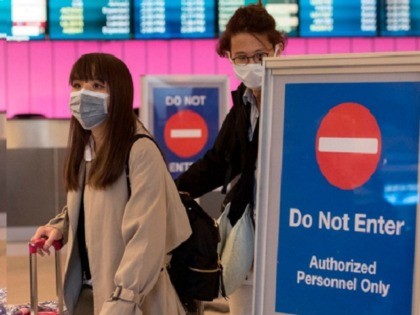 Passengers wear protective masks to protect against the spread of the Coronavirus as they