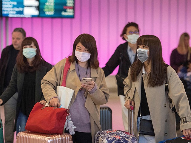 TOPSHOT - Passengers wear protective masks to protect against the spread of the Coronavirus as they arrive at the Los Angeles International Airport, California, on January 22, 2020. - A new virus that has killed nine people, infected hundreds and has already reached the US could mutate and spread, China …