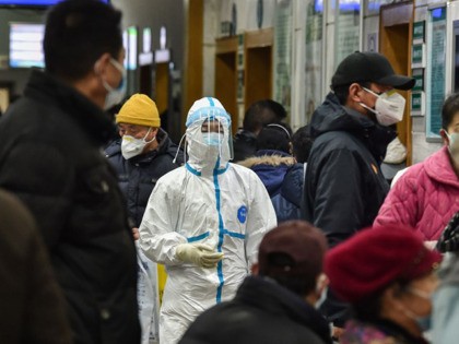 TOPSHOT - A medical staff member (C) wearing protective clothing to help stop the spread of a deadly virus which began in the city, walks at the Wuhan Red Cross Hospital in Wuhan on January 24, 2020. - Chinese authorities rapidly expanded a mammoth quarantine effort aimed at containing a …