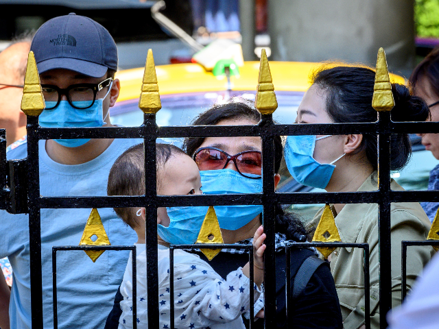 Tourists with face masks look at Erawan shrine, a popular spritual landmark in Bangkok on January 27, 2020. - Thailand has detected eight Coronavirus cases so far -- three of whom are receiving treatment in hospital and five of whom have been discharged, according to a statement from Health Minister …