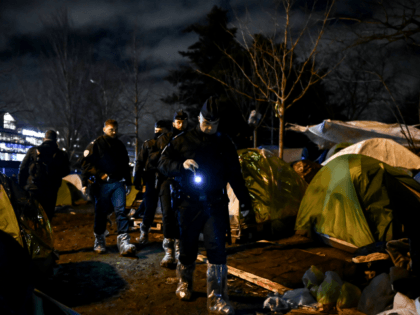 police forces look for migrants to be evacuated early morning on January 28, 2020, in Paris. - Between 900 and 1800 people were living in this area. (Photo by Philippe LOPEZ / AFP) (Photo by PHILIPPE LOPEZ/AFP via Getty Images)