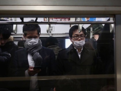 Passengers wearing protective facemasks commute on a subway train in Tokyo on January 28, 2020. - Japanese authorities said a man with no recent travel to China has contracted the novel strain of coronavirus -- apparently after driving tourists visiting from Wuhan, where a deadly outbreak began. (Photo by Behrouz …