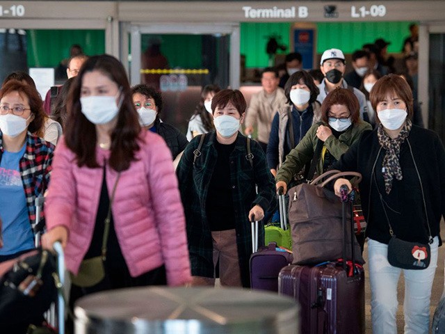 Passengers wear protective masks to protect against the spread of the Coronavirus as they