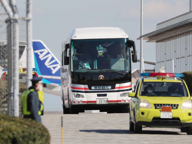 A bus (C) carrying Japanese citizens departs following the arrival of the second charter f