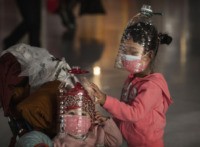 BEIJING, CHINA - JANUARY 30: Chinese children wear plastic bottles as makeshift homemade protection and protective masks while waiting to check in to a flight at Beijing Capital Airport on January 30, 2020 in Beijing, China. The number of cases of a deadly new coronavirus rose to over 7000 in …