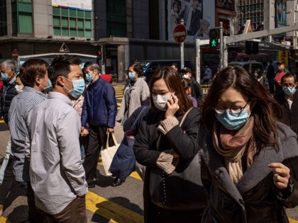 HONG KONG, CHINA - JANUARY 31: Residents wear surgical mask as they cross a street in a sh