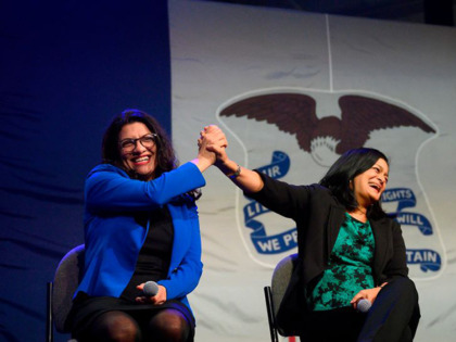 US Congresswoman Rashida Tlaib (L), D-MI, high-fives US Congresswoman Pramila Jayapal (C),