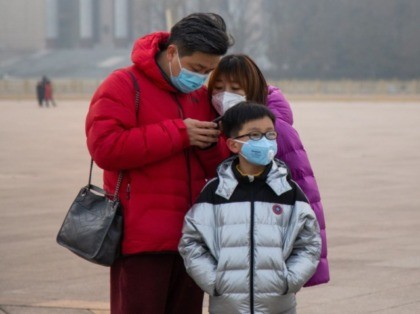 BEIJING, CHINA - JANUARY 26: A family wearing masks stands in Tiananmen Square on January