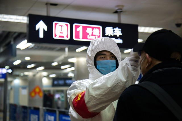 BEIJING, CHINA - JANUARY 26: A health worker checks the temperature of a man entering the subway on January 26, 2020 in Beijing, China. The number of cases of coronavirus rose to 1,975 in mainland China on Sunday. Authorities tightened restrictions on travel and tourism this weekend after putting Wuhan, …