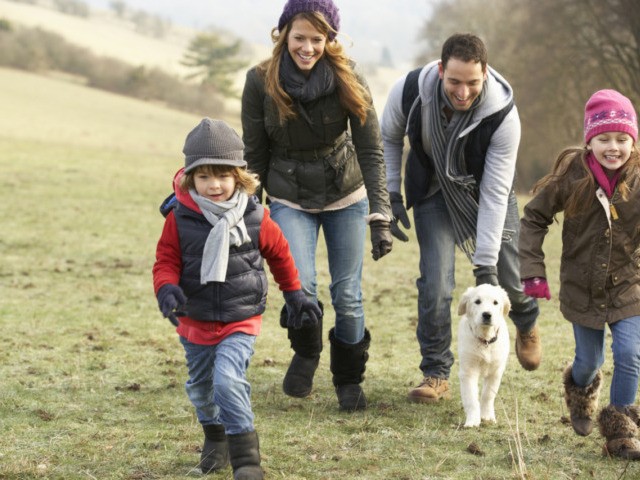 Family and dog having fun in the country in winter.