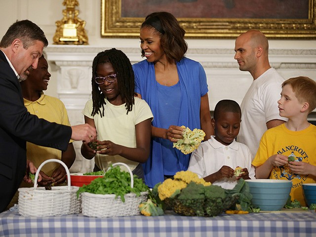 WASHINGTON, DC - JUNE 12: U.S. first lady Michelle Obama (C) and West Virginia Department of Education Office of Child Nutrition Executive Director Richard Goff (L) help students from five District of Columbia schools make a meal using the summer crop from the White House Kitchen Garden in the State …