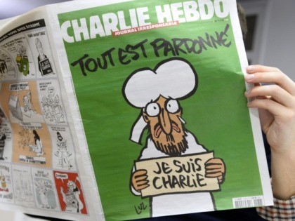 A man reads, in a newsroom in Paris, the last issue of French satirical weekly Charlie Heb