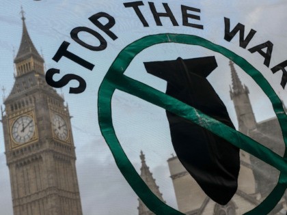 LONDON, ENGLAND - DECEMBER 02: Stop the War Coalition supporters hold up a banner outside the Houses of Parliament on December 2, 2015 in London, England. A day long debate on whether Britain should become involved with airstrikes targetting Islamic State targets in Syria will end in a vote at …