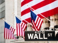 Wall Street Sign with New York Stock Exchange Building Out Of Focus In The Background