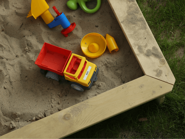 BERLIN, GERMANY - AUGUST 31: A sandbox with a child's toys lies in a garden on August