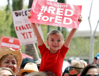 PHOENIX, AZ - APRIL 26: A young student holds up a sign in support of Arizona teachers dur