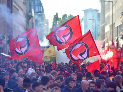 Participants of the "Revolutionary 1st of May Demonstration" light flares and wave flags of the left-wing, Anti-Fascist Antifa movement during May Day events on May 1, 2018 in Berlin. (Photo by John MACDOUGALL / AFP) (Photo credit should read JOHN MACDOUGALL/AFP via Getty Images)