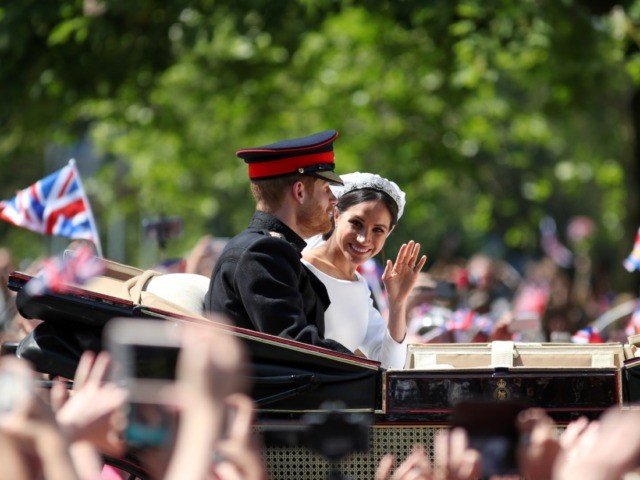 TOPSHOT - Britain's Prince Harry, Duke of Sussex and his wife Meghan, Duchess of Sussex wave from the Ascot Landau Carriage during their carriage procession on the Long Walk as they head back towards Windsor Castle in Windsor, on May 19, 2018 after their wedding ceremony. [Photo by Daniel LEAL-OLIVAS …