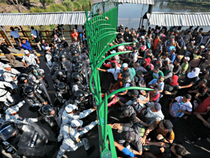 Migrants charge on the Mexican National Guardsmen at the border crossing between Guatemala and Mexico in Tecun Uman, Guatemala, Saturday, Jan. 18, 2020. More than a thousand Central American migrants surged onto the bridge spanning the Suchiate River, that marks the border between both countries, as Mexican security forces attempted …