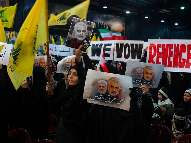 Supporters of Hezbollah leader Sayyed Hassan Nasrallah wave flags and placards that say "we vow revenge," ahead of the leader's televised speech in a southern suburb of Beirut, Lebanon, Sunday, Jan. 5, 2020 following the U.S. airstrike in Iraq that killed Iranian Revolutionary Guard Gen. Qassem Soleimani. The placard in …