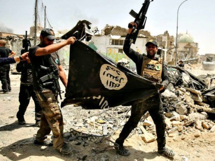 Members of the Iraqi Counter-Terrorism Service (CTS) cheer as they carry upside-down a bla