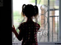 In this Thursday, June 6, 2019, photo, Victory looks out the front door as she plays at home in Ogden, Utah. When doctors said her youngest child would be a girl, Amie Schofield chose the name Victoria. Then the prediction changed to boy, so she switched to Victor. It turned …